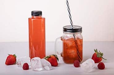 Lækker velsmagende jordbærsaft i retrokrus og plastflaske