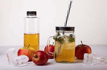 Læskedrik med æblesaft i plastflaske og retrokrus
